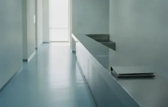 מסדרון מוסדי ריק עם דלפק ותיקייה סגורה ואור טבעי חזק מהקצה, בהקשר של עיקול דמי שכירות