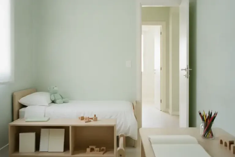 חדר ילדים מסודר וריק עם דלת פתוחה למסדרון